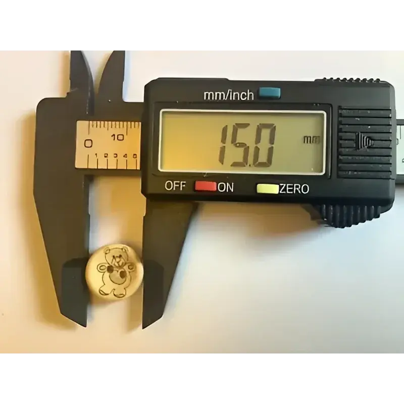 Digital caliper measuring a teddy bear button.