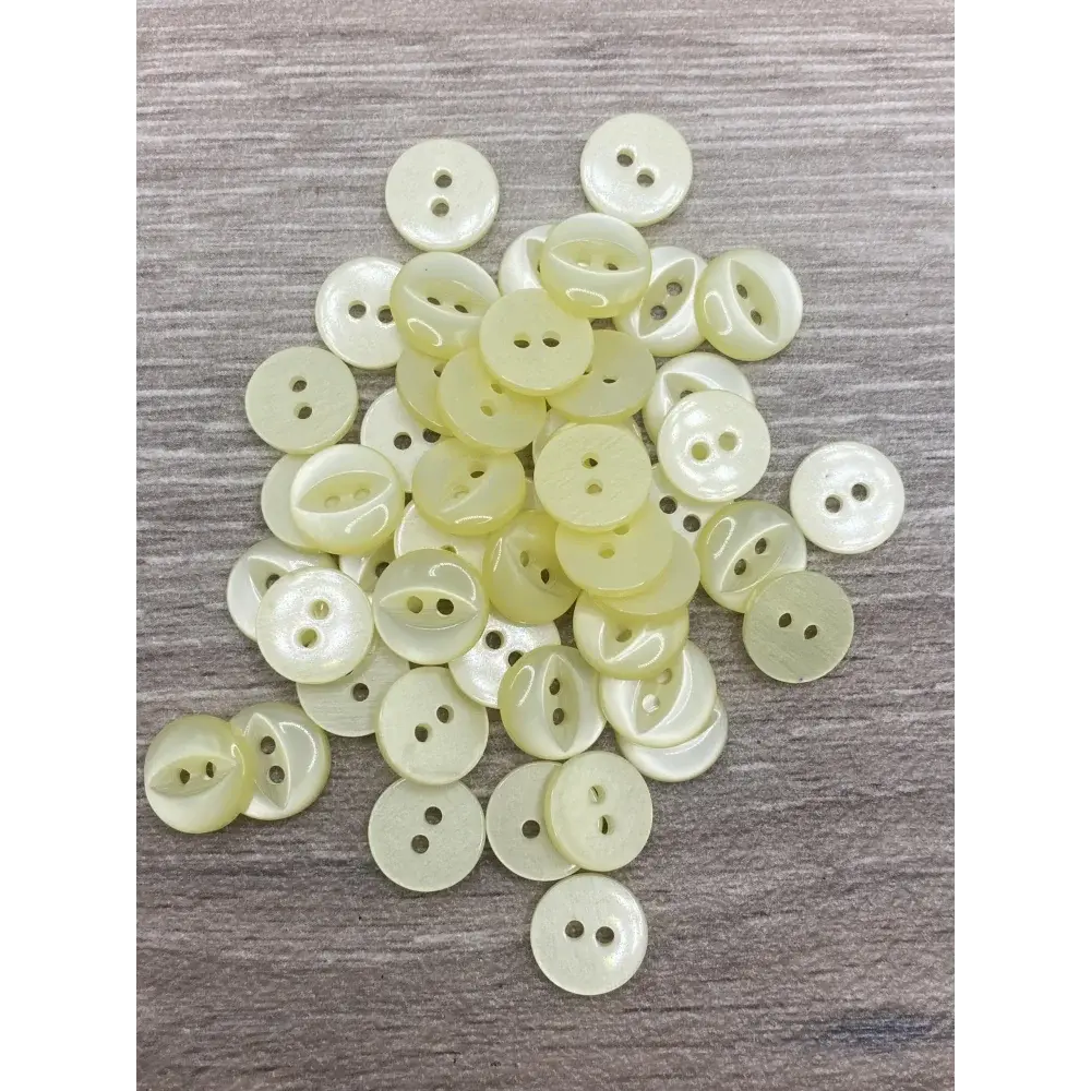 Pile of two-hole, pale yellow buttons.