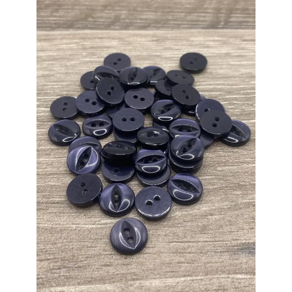Pile of dark-colored, two-hole buttons.