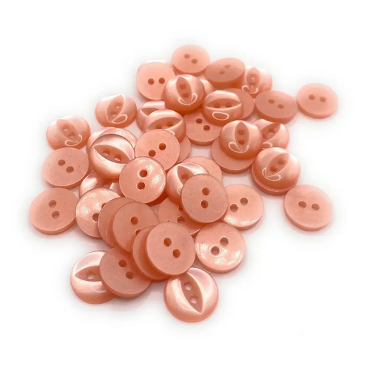 Pile of peach-colored, two-hole buttons.