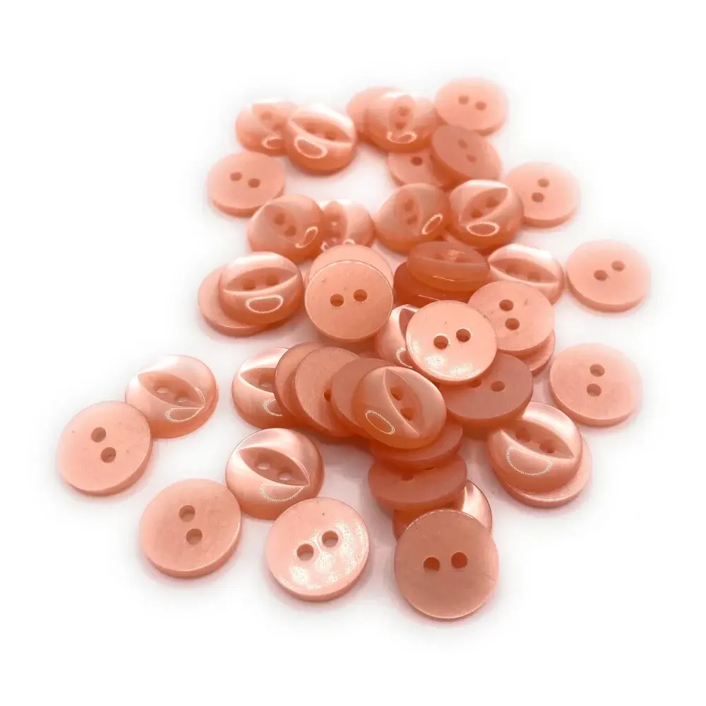 Pile of peach-colored, two-hole buttons.