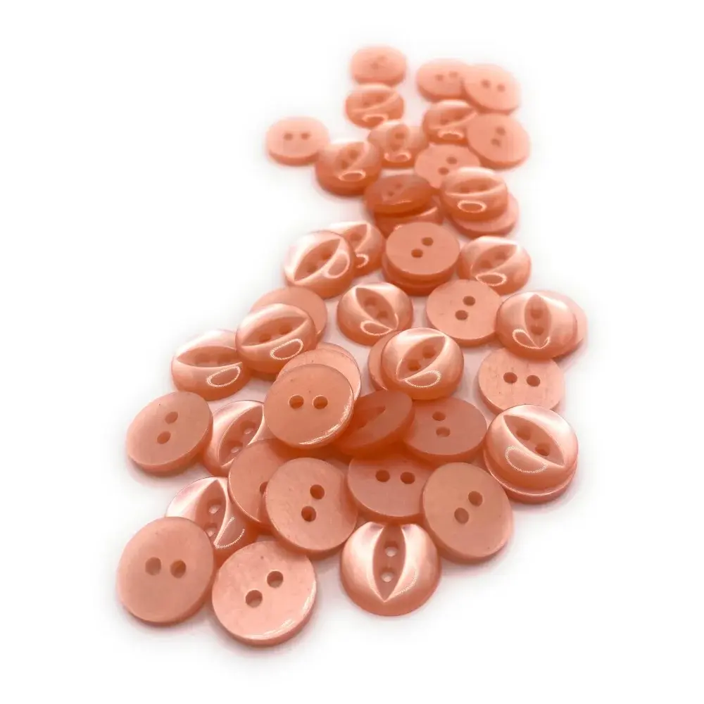 Pile of peach-colored sewing buttons.