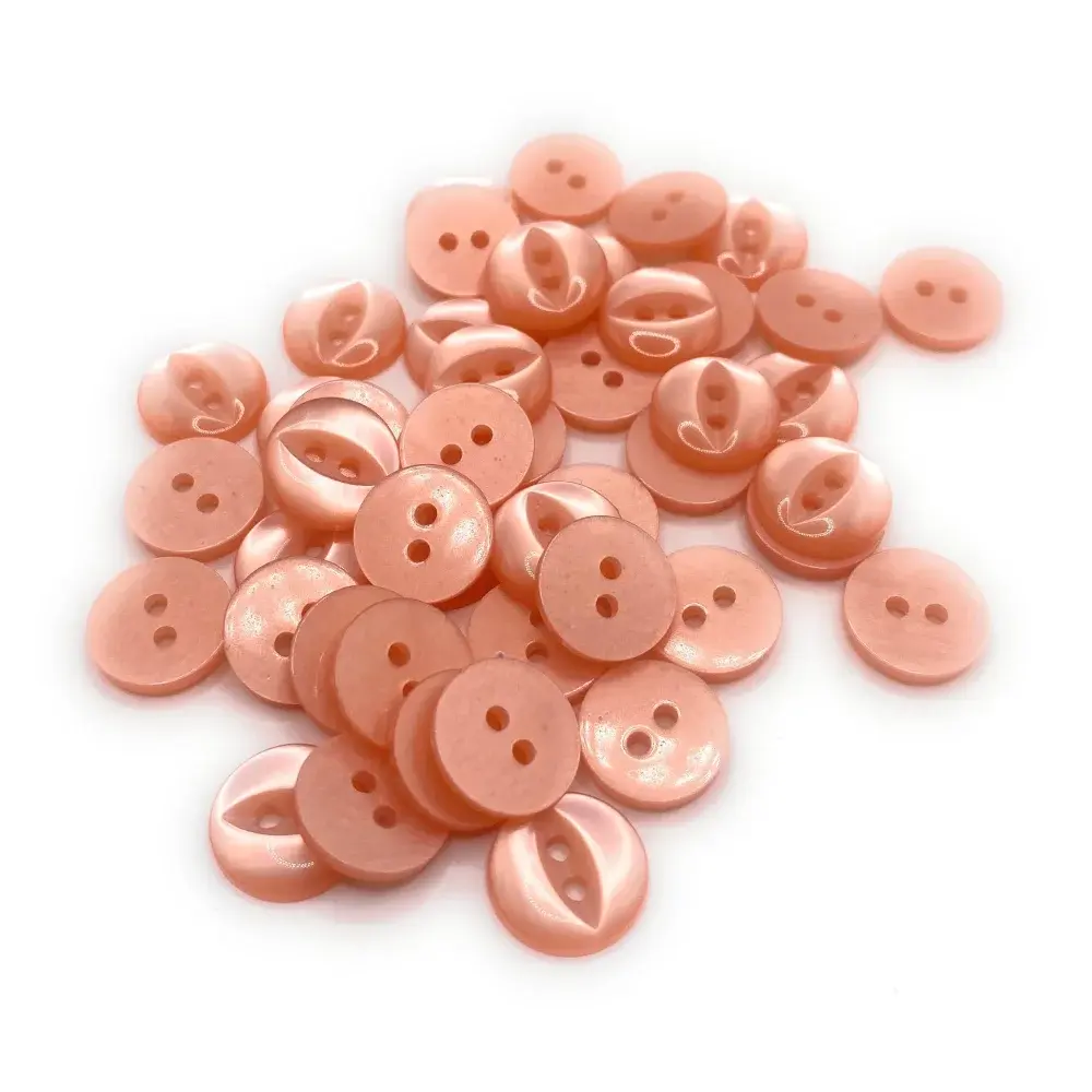 Pile of peach-colored, two-hole buttons.