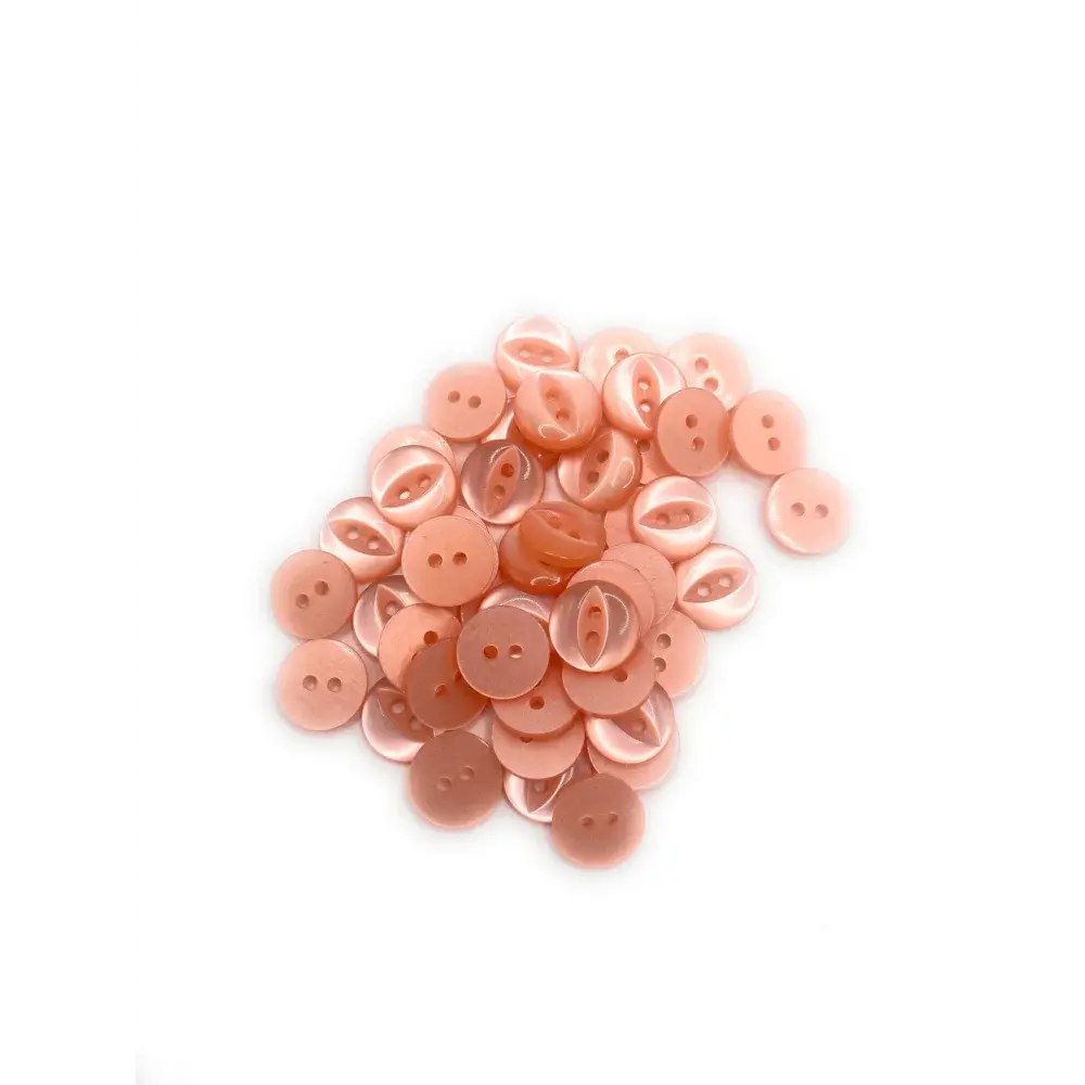 Pile of peach-colored, two-hole buttons.