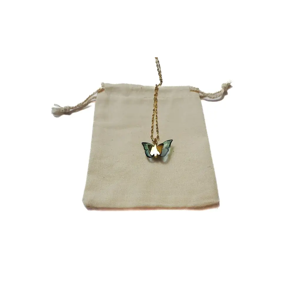 Butterfly pendant necklace on a drawstring bag.