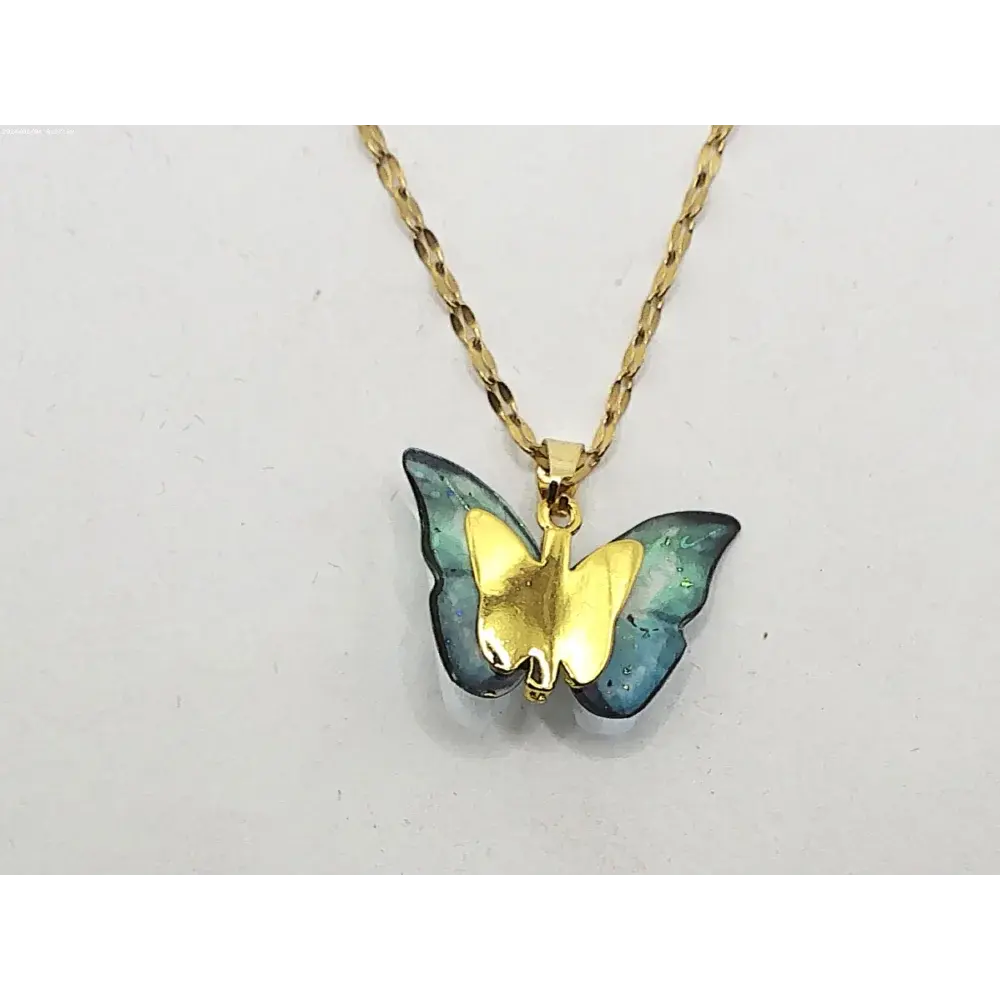 Gold chain necklace with butterfly pendant.
