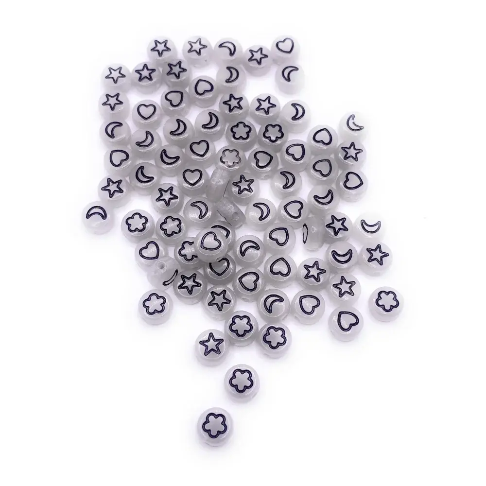 Pile of white beads with black shapes.