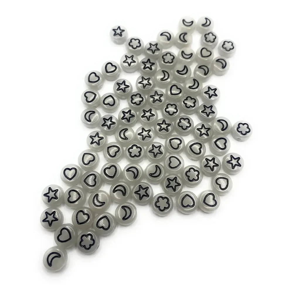 Pile of gray beads with star, heart, moon, and flower shapes.