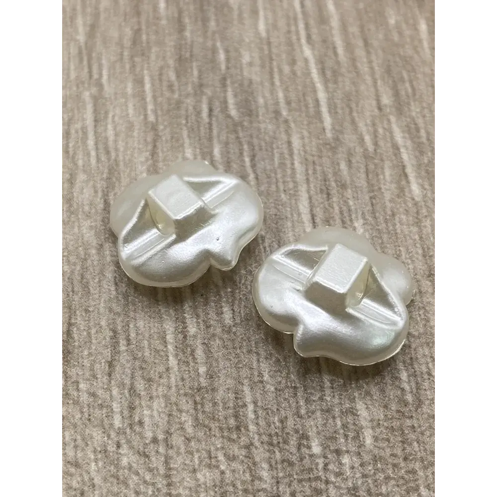 Two pearlescent flower-shaped buttons.