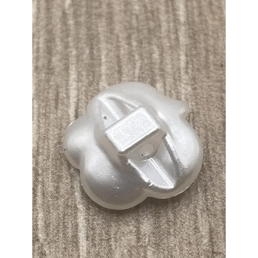 White, flower-shaped button with shank.