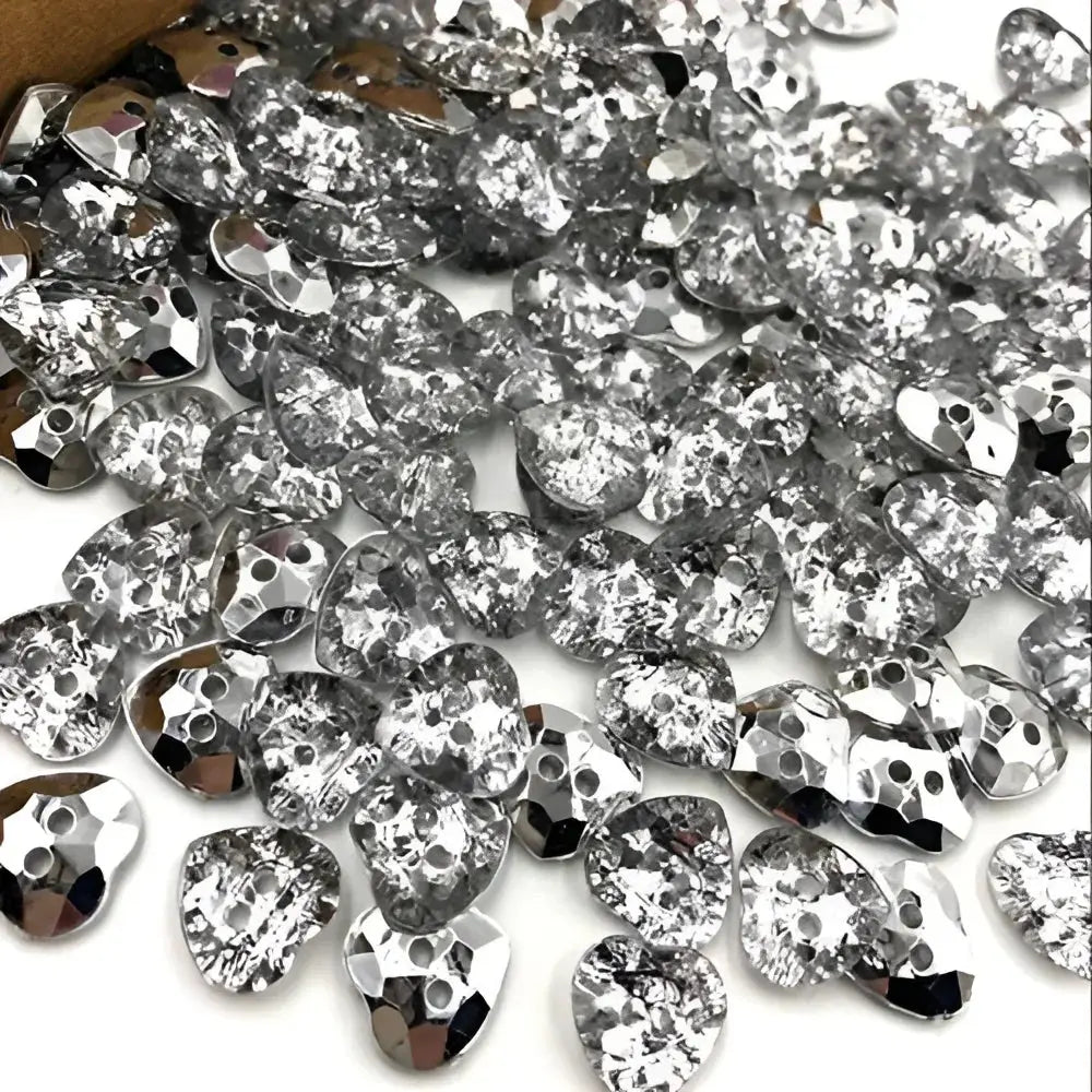 Pile of silver heart-shaped rhinestones.