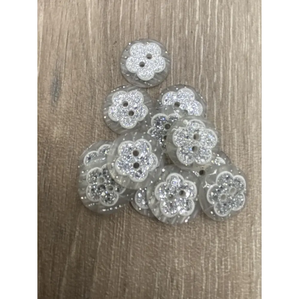 Pile of flower-shaped glittery buttons.