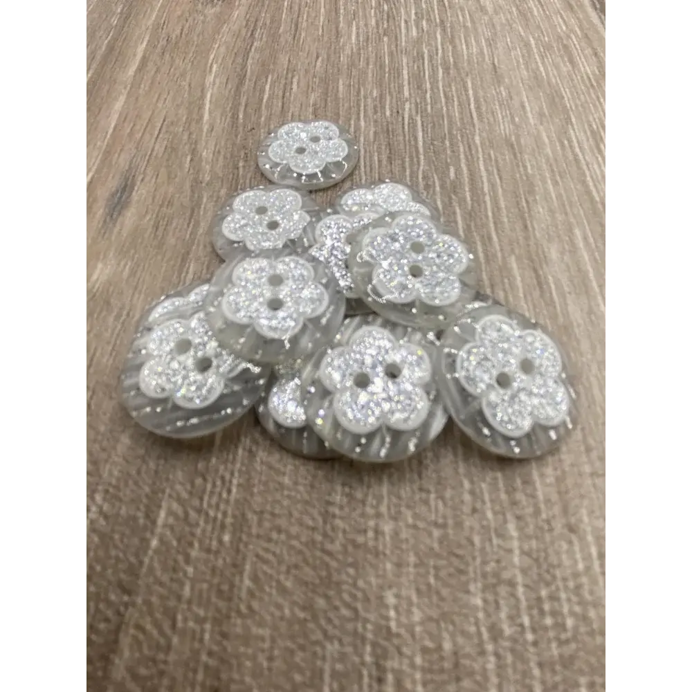 Pile of flower-shaped, glittery buttons.