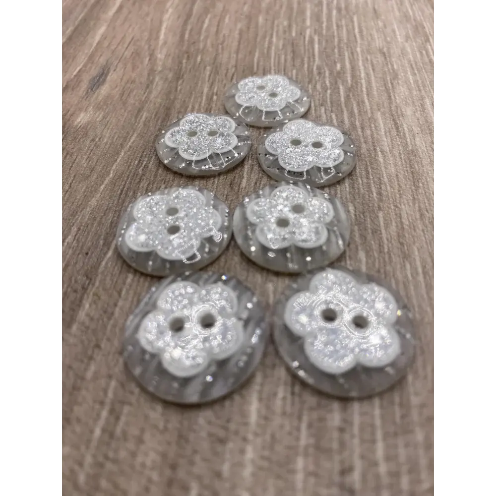 Seven flower-shaped, clear, two-hole buttons.