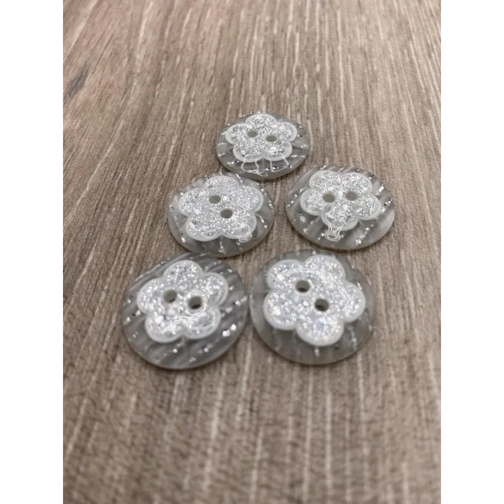 Five flower-shaped, glittery buttons.