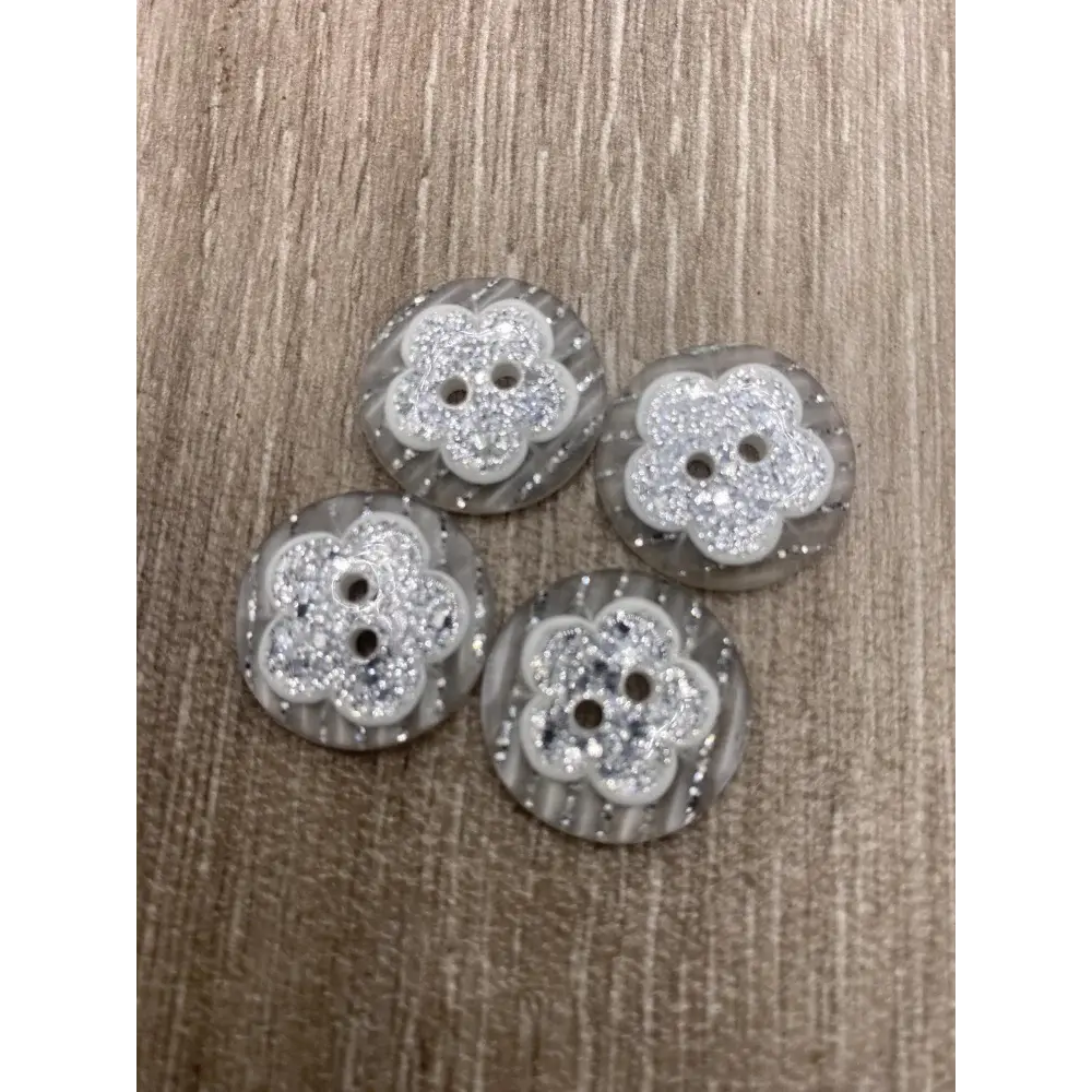 Four flower-shaped, glittery buttons.