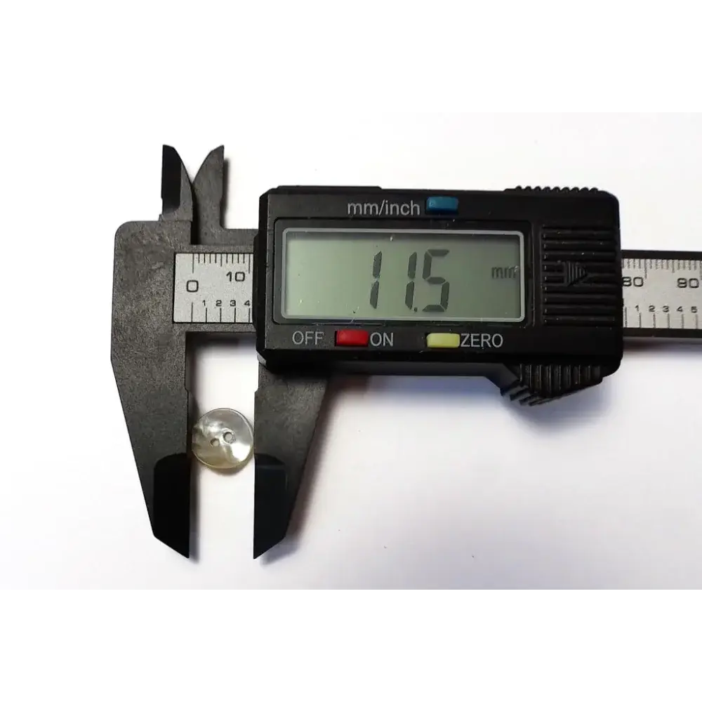 Button being measured with digital calipers.