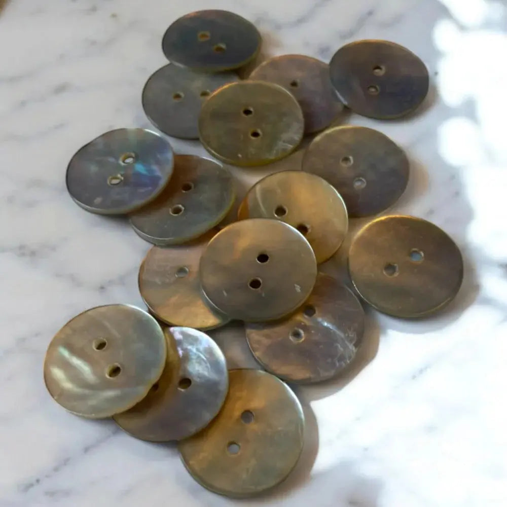 Pile of iridescent two-hole buttons.