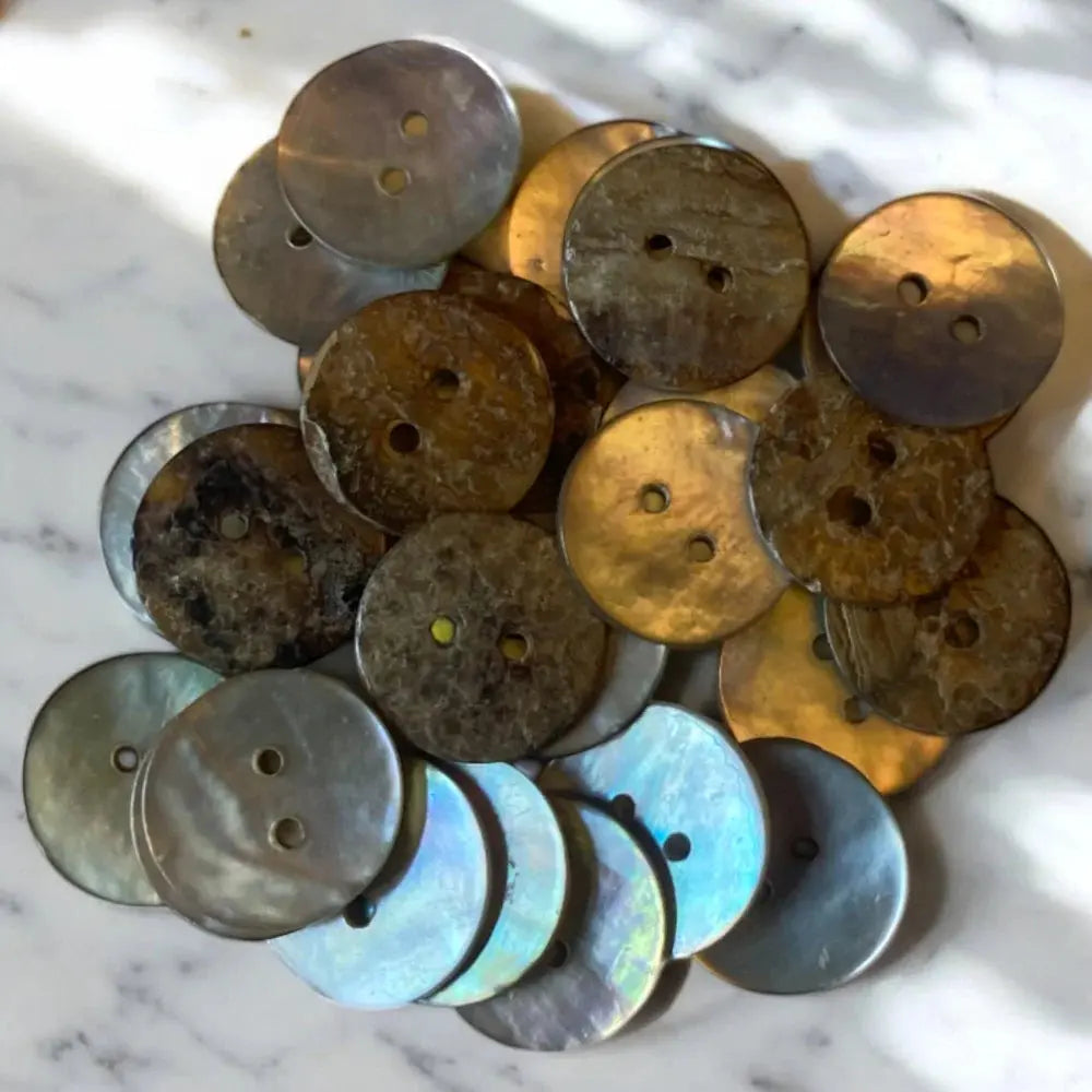 Pile of iridescent two-hole buttons.