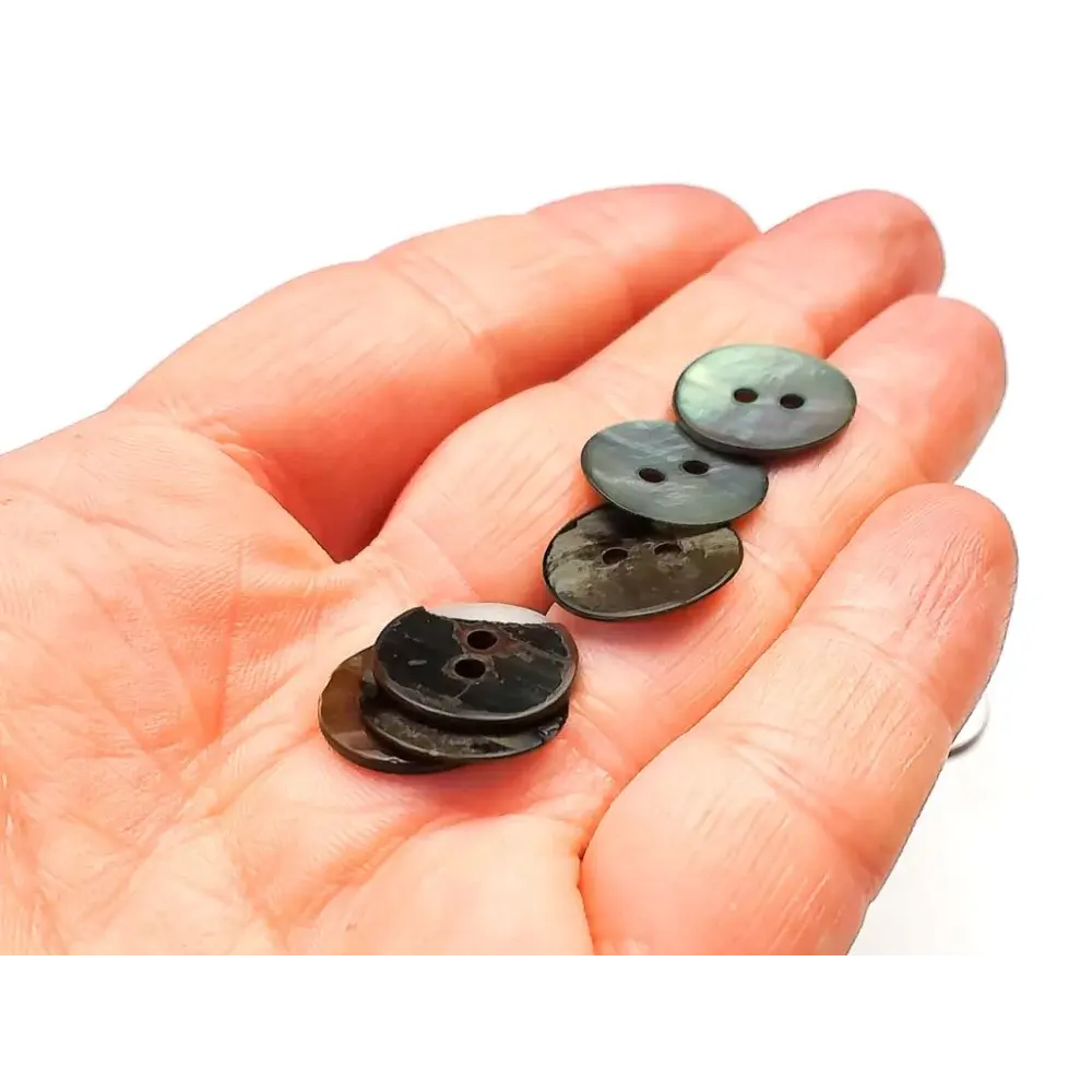 Hand holding iridescent buttons.