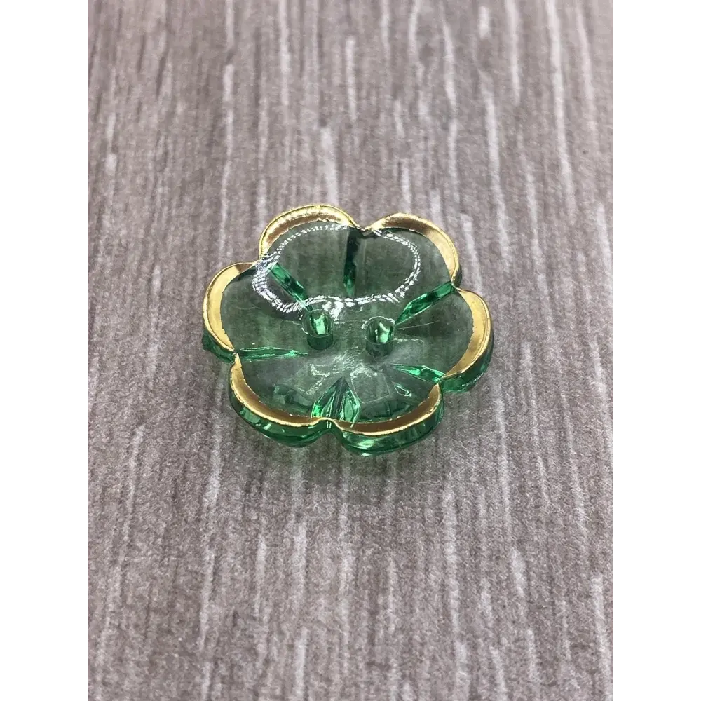 Green glass flower with gold trim.