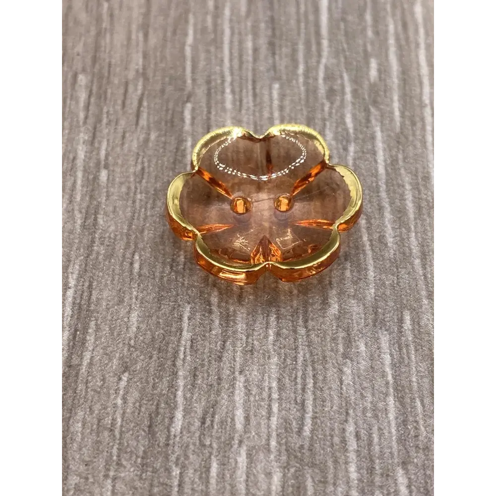 Peach-colored glass trinket dish with gold trim.