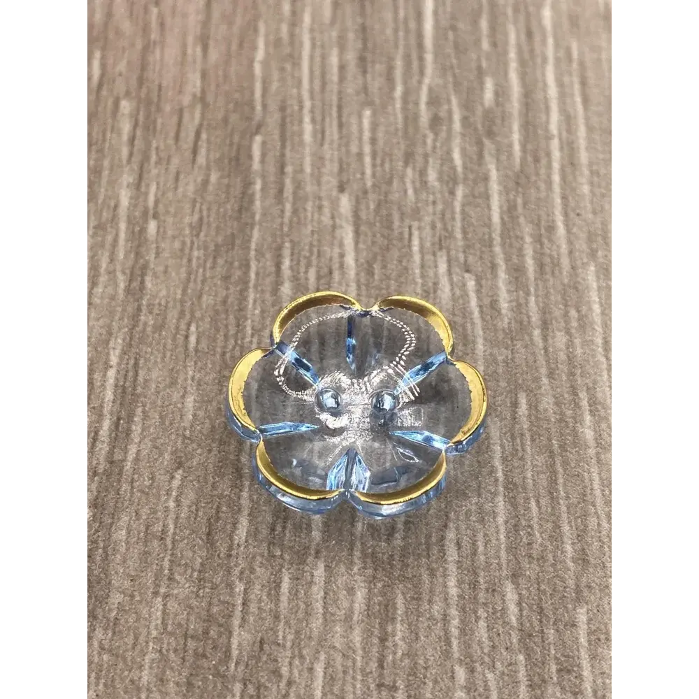 Blue glass flower-shaped dish with gold trim.