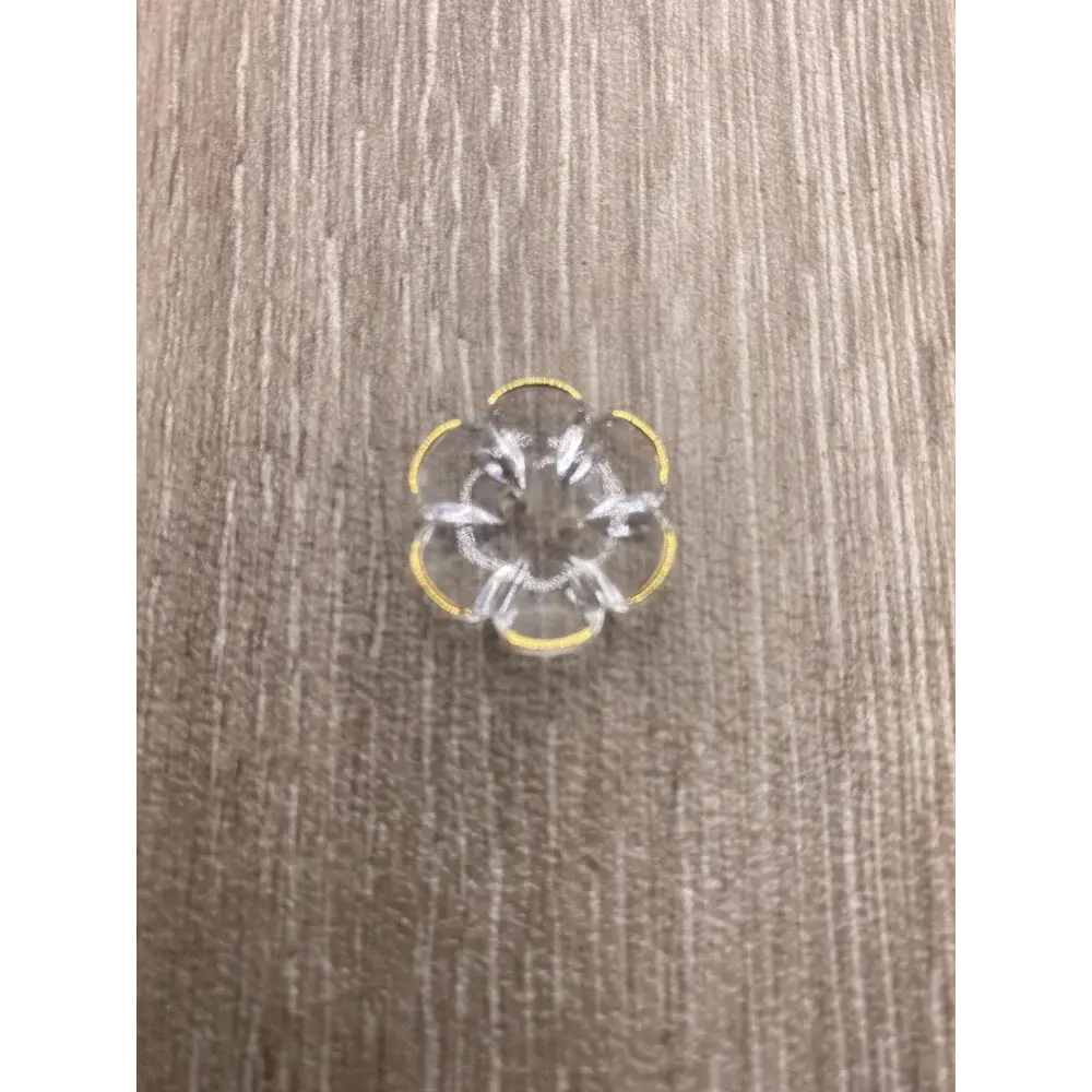 Clear flower-shaped button with yellow trim.