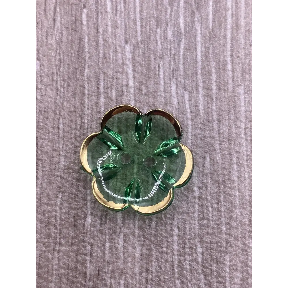 Green flower-shaped button with gold trim.