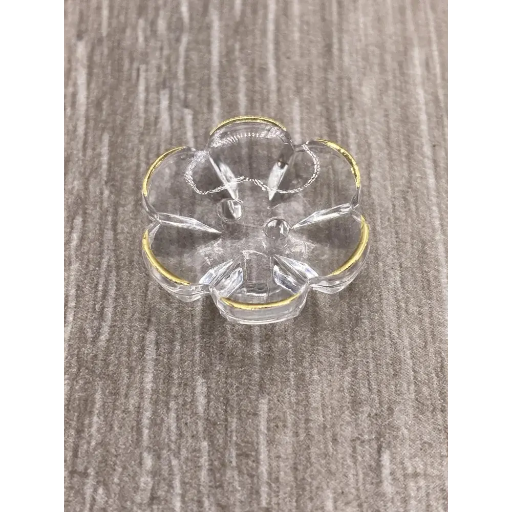 Clear glass flower-shaped dish with gold trim.