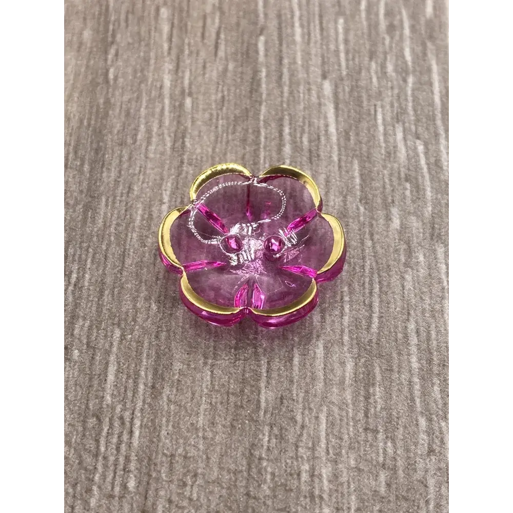 Pink and gold flower-shaped jewelry holder with jewelry.