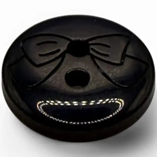 Black button with bow tie and smile.