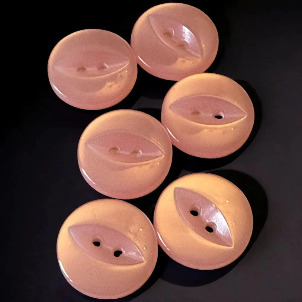 Peach-colored, round, two-hole buttons.