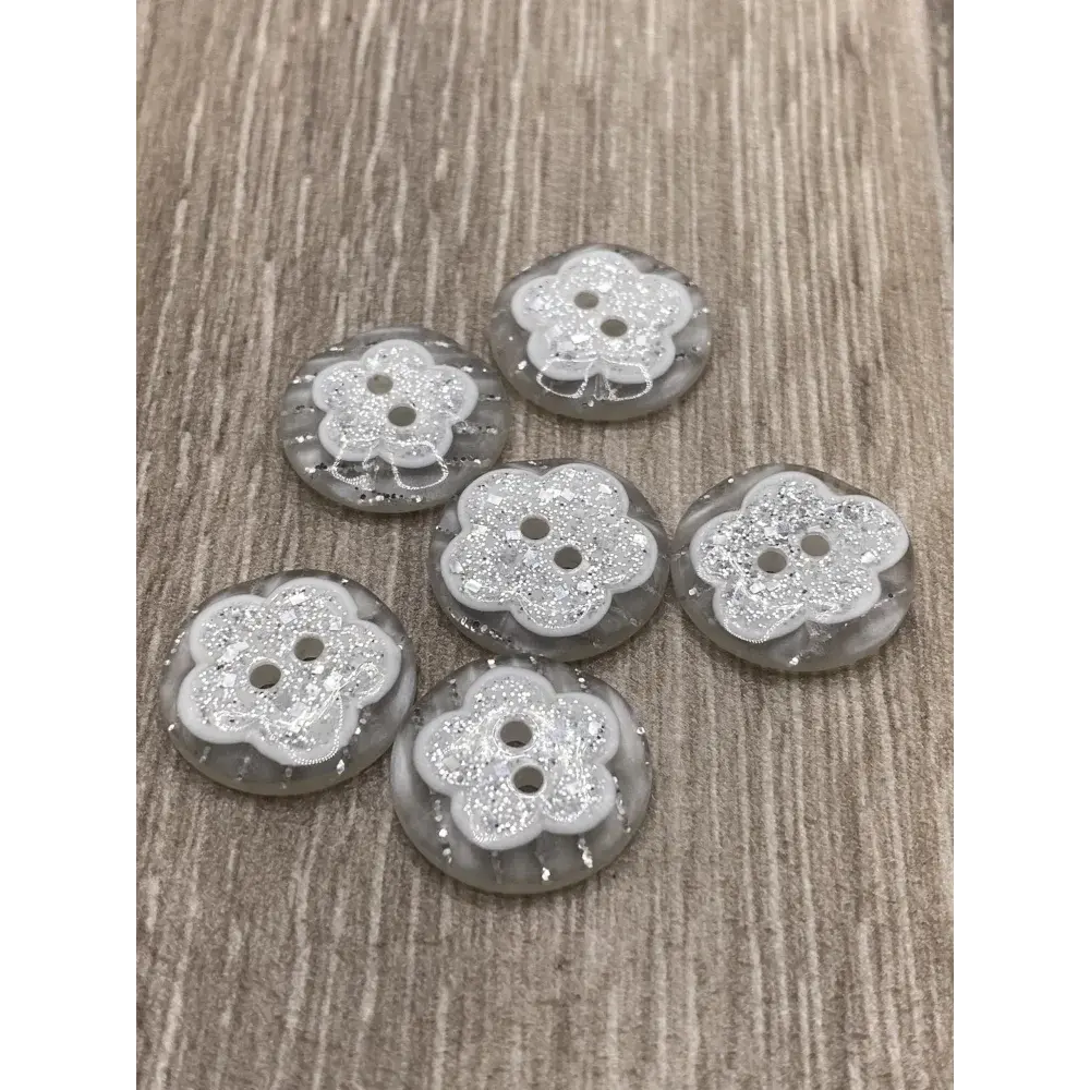 Six flower-shaped glittery buttons.