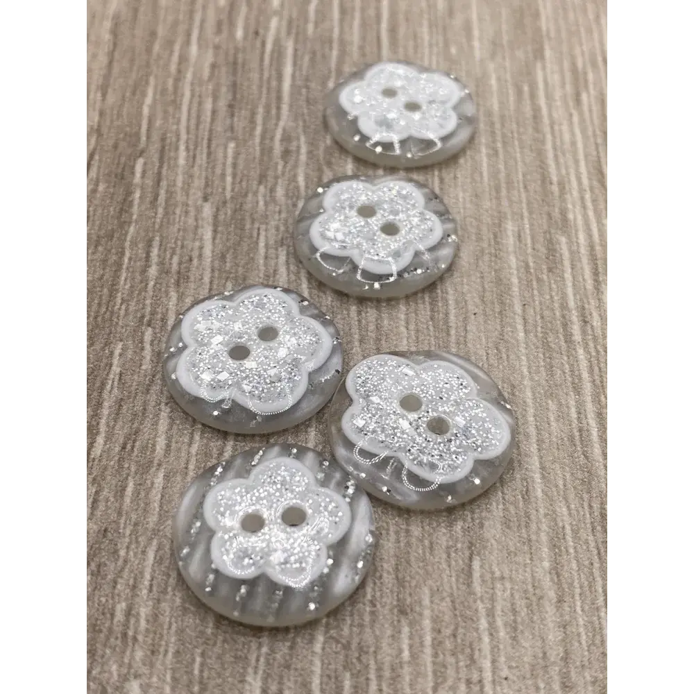 Five gray flower-shaped buttons.