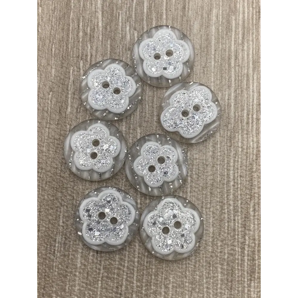 Seven flower-shaped, glittery buttons.