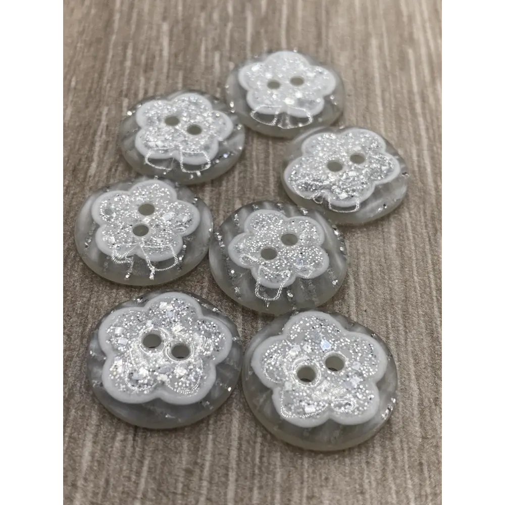 Seven flower-shaped glittery buttons.
