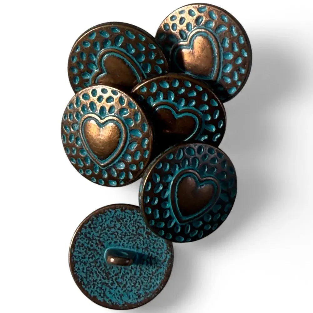 Pile of heart-stamped, turquoise-accented, bronze buttons.