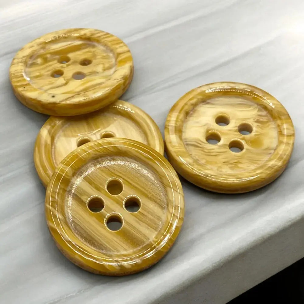 Four-holed, striped, yellow buttons.