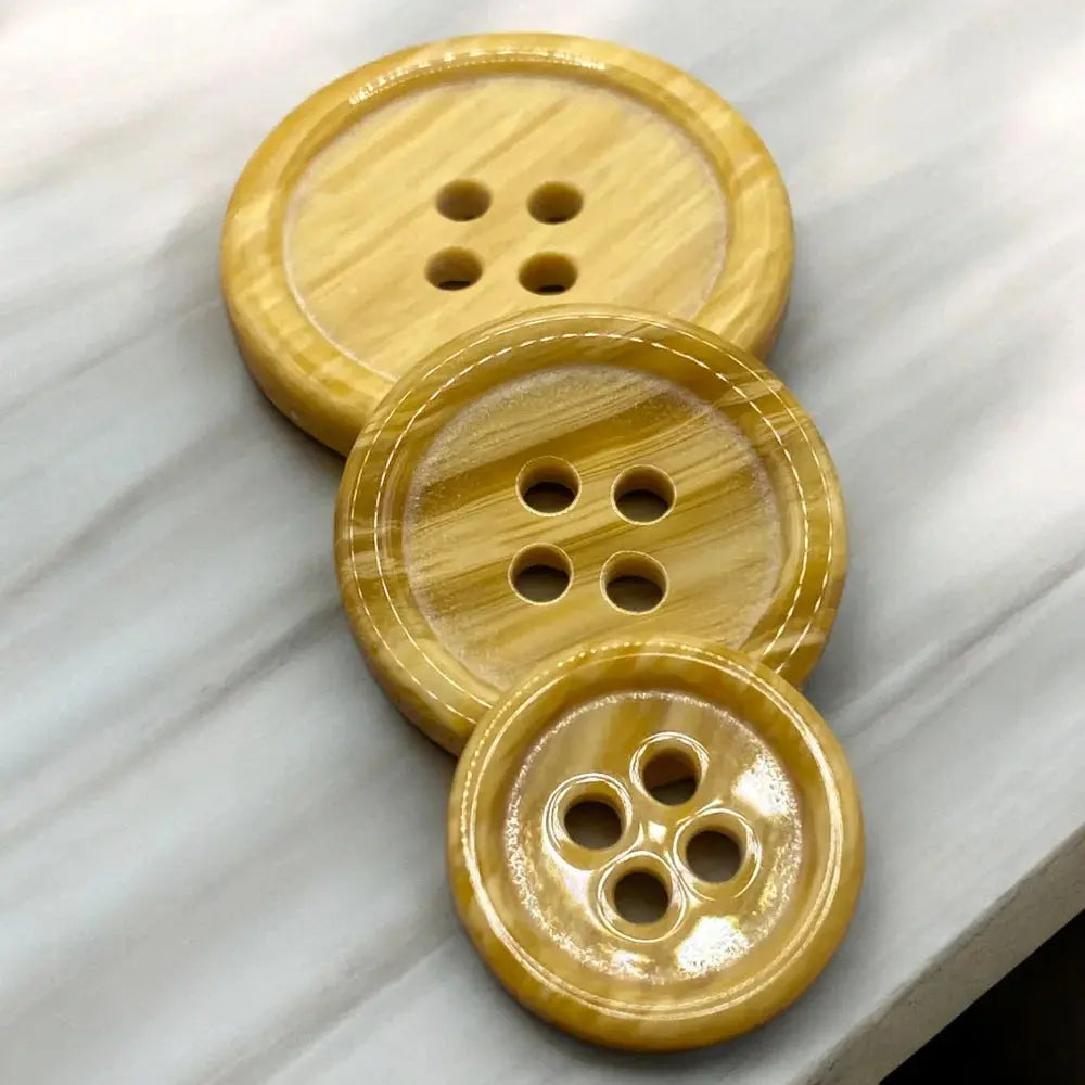 Three stacked, four-hole, wooden buttons.