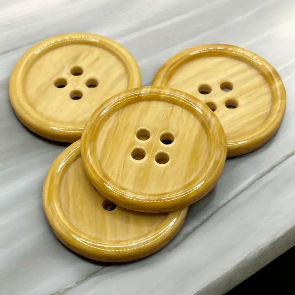 Four-hole, round, tan buttons.