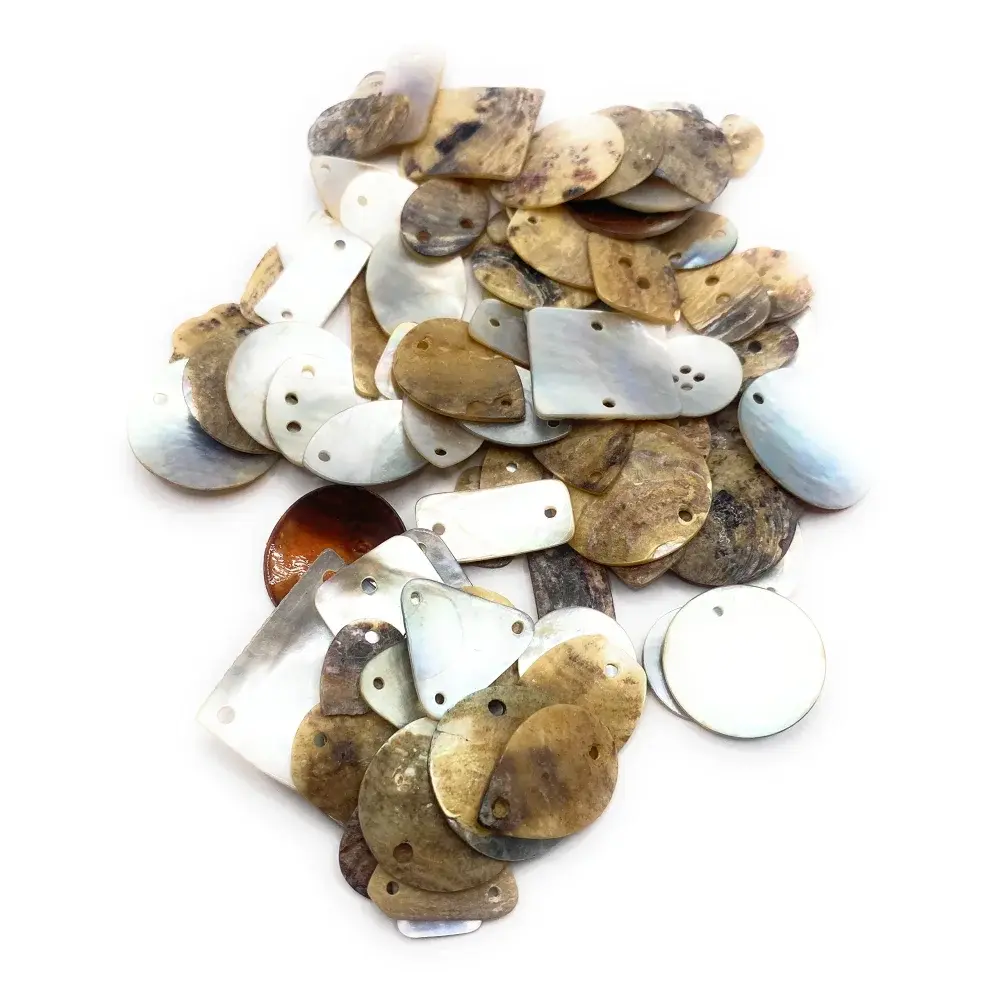Pile of drilled, irregularly shaped shell pieces.