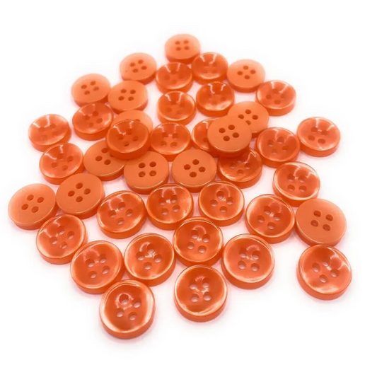 Pile of orange four-hole buttons.