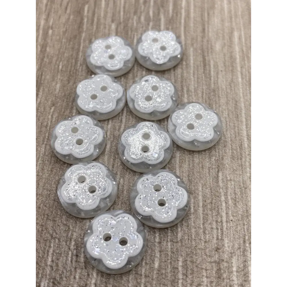 Flower-shaped, glittery, three-hole buttons.