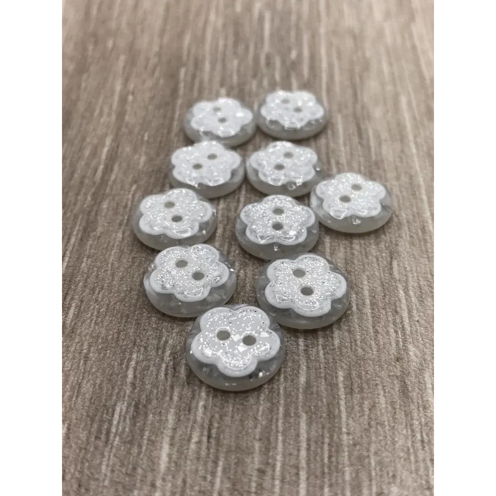 Flower-shaped, glittery, gray buttons.