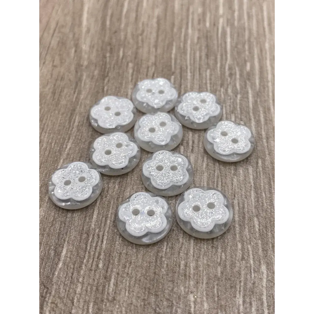 Flower-shaped, glittery, two-hole buttons.