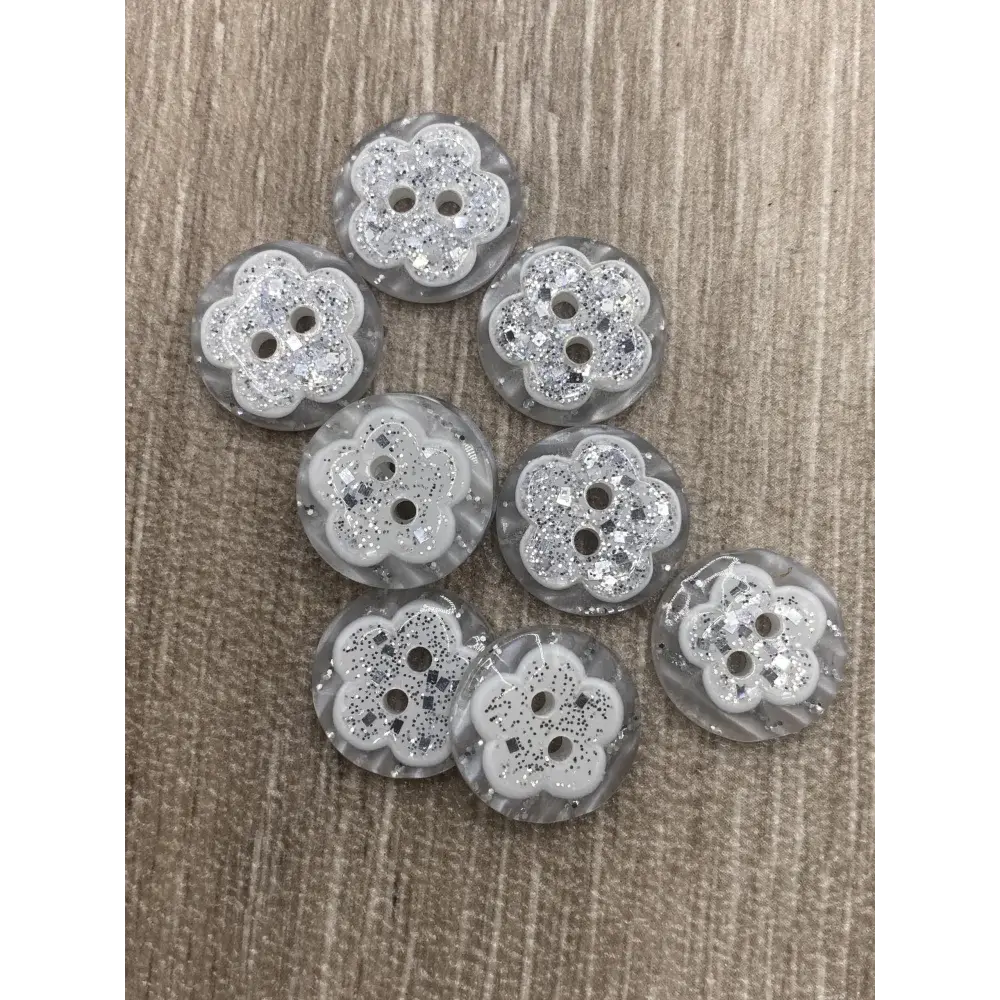 Eight flower-shaped, glittery buttons.