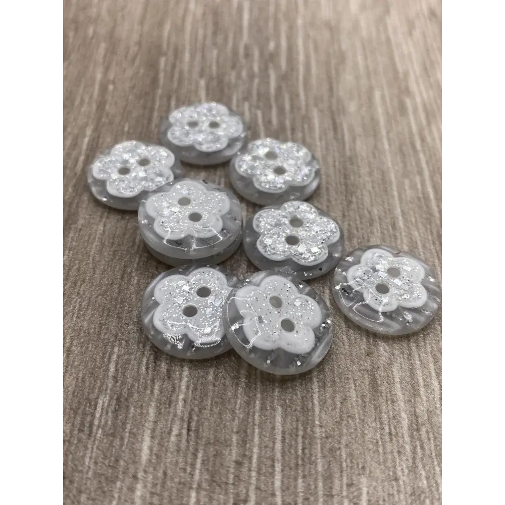 Eight flower-shaped, glittery buttons.