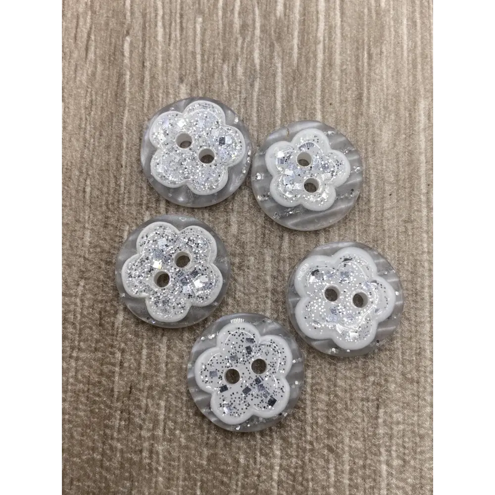 Five flower-shaped glittery buttons.