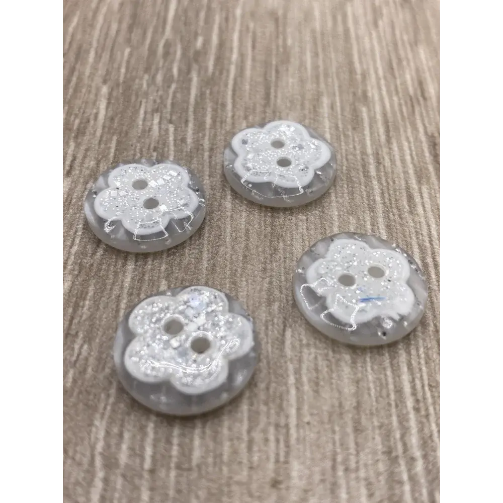 Four flower-shaped, two-hole buttons.